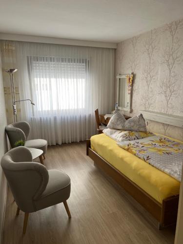 Altstadt Hotel Cochem في كوشيم: غرفة نوم بسرير وكراسي ونافذة