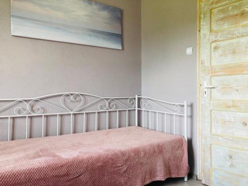 - une chambre avec un lit blanc et une couverture rose dans l'établissement Pie Oskara, à Kolka