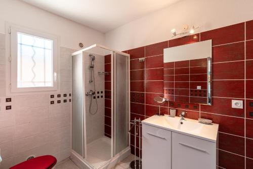 een badkamer met een douche, een wastafel en een spiegel bij Torra Mare in Cervione