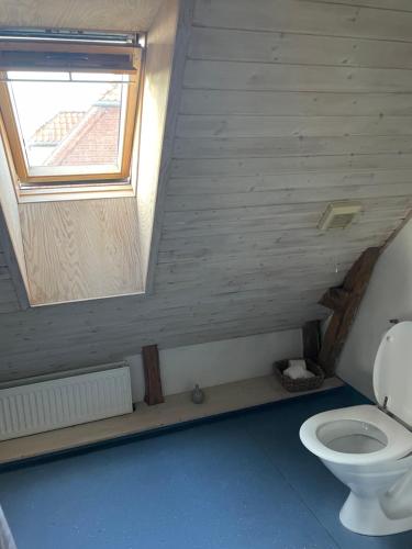 uma casa de banho com um WC e uma janela em Aabels em Sæby