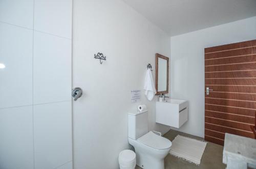 a white bathroom with a toilet and a shower at Kariza in Yzerfontein