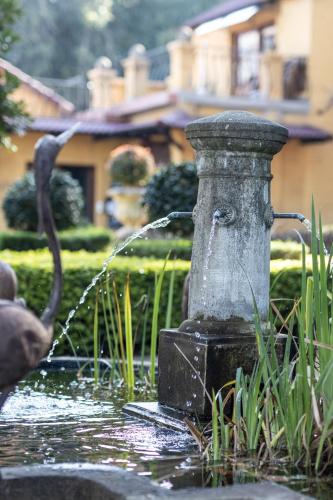 a water fountain in a yard with a bird bath at The Tuscan Garden in Newcastle
