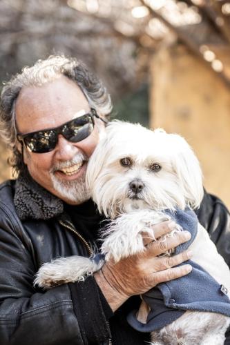 a man holding a white dog in his arms at The Tuscan Garden in Newcastle