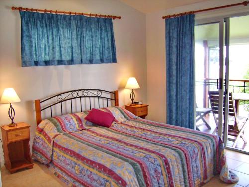 a bedroom with a bed with a colorful comforter at Coast and Country Cabin 4 