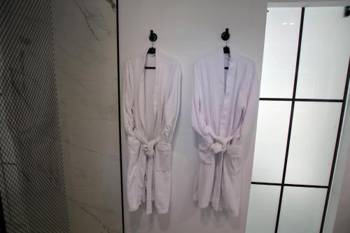 dos toallas blancas colgando en una pared en un baño en TESS Villa Le Clos Fleury en Alhaurín de la Torre