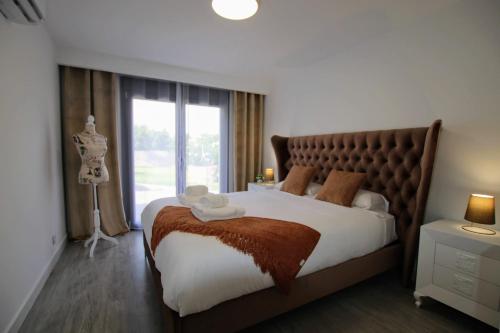 een slaapkamer met een groot bed en een groot raam bij TESS Villa Le Clos Fleury in Alhaurín de la Torre