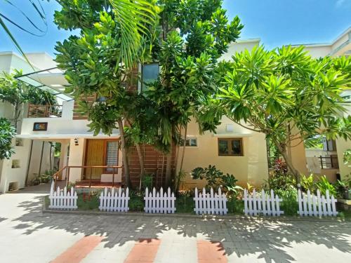 a house with a white picket fence in front of it at Coral Drive Villas -Your Private Beach Destination in Chennai