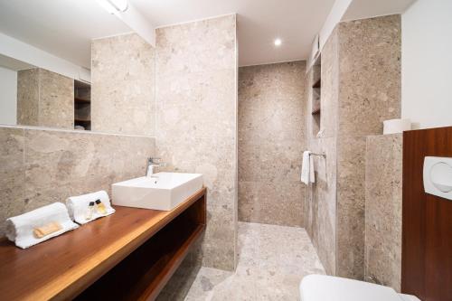 a bathroom with a sink and a mirror at Résidence Tropic Appart Hotel in Saint-Gilles les Bains