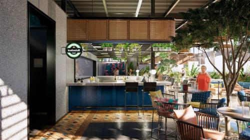 a restaurant with a counter and tables and chairs at Zone By The Park Gopalpur in Gopālpur
