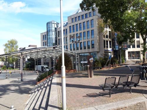 a group of benches in a city with a building at Tonis Apartment Erkrath in Erkrath