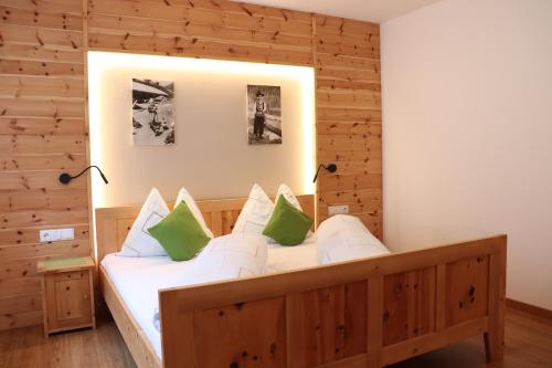 een slaapkamer met een bed met een houten muur bij Schneiderhof in Valdurna