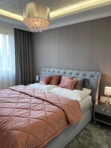 a bedroom with a large bed with pink pillows at Apartmány Residence in Donovaly