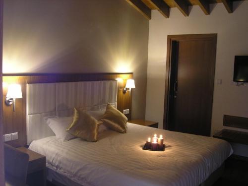 a bedroom with a large bed with candles on it at Livadia Hotel Kyperounta in Kyperounda