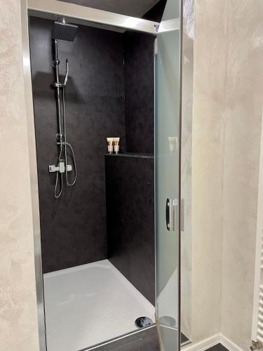 a shower with a glass door in a bathroom at Apartmány GRENT Donovaly in Donovaly