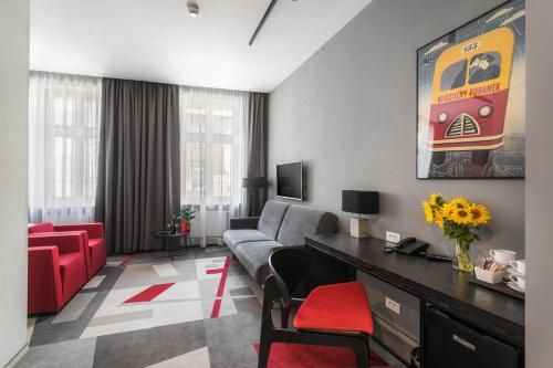 克拉科夫的住宿－Dada Premium Aparthotel，带沙发和红色椅子的客厅