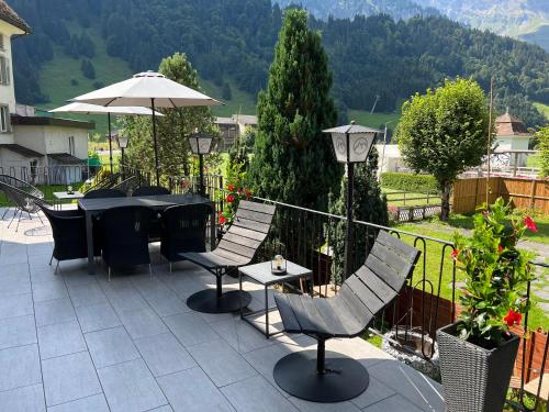 a patio with a table and chairs and an umbrella at GRAND your home with common kitchens with self check-in in Engelberg