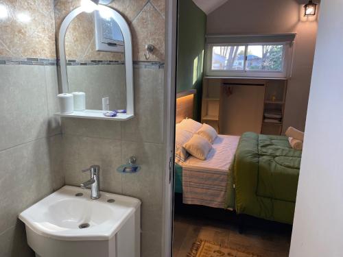 a small bathroom with a sink and a bed at CasitaLiu in Villa General Belgrano