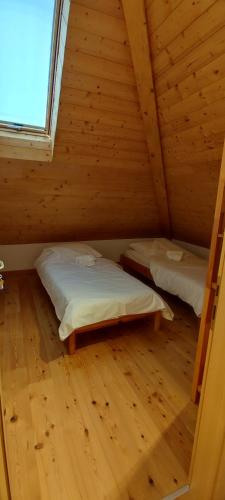 a room with two beds in a wooden cabin at Hostel Borik in Ðurđevac