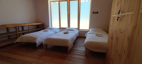 a room with three beds and a window at Hostel Borik in Ðurđevac