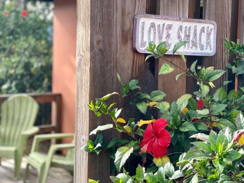 a sign on the side of a house with a flower at Esperanza Inn Guesthouse in Vieques