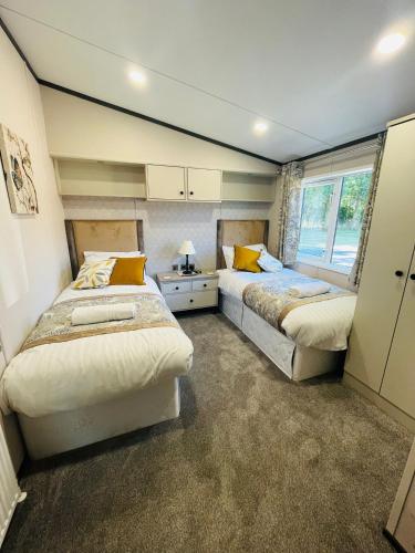 a bedroom with two beds and a window at Laburnum Lodge with Hot Tub in York