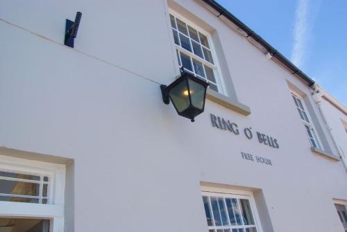 ein Straßenlicht hängt an der Seite eines weißen Gebäudes in der Unterkunft Ring O Bells in Chagford