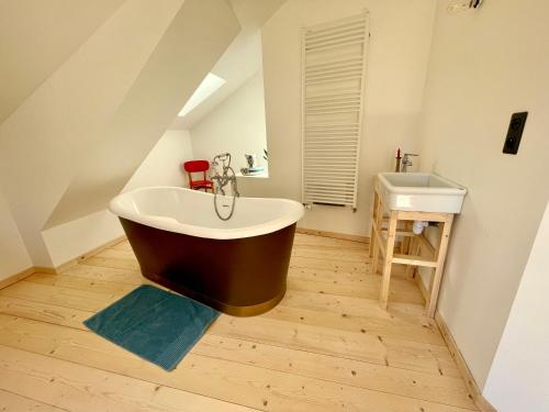 a bathroom with a large bath tub and a sink at Maison près de la rivière in Arbois