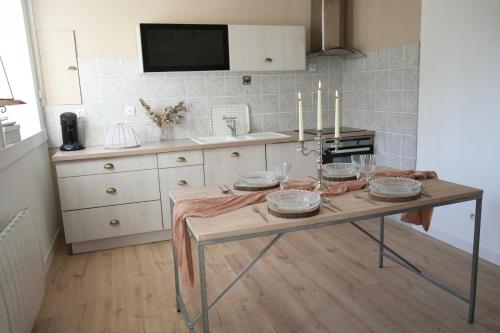 - une cuisine avec une table et des bougies dans l'établissement Le Cocon de Noah, à Sideville