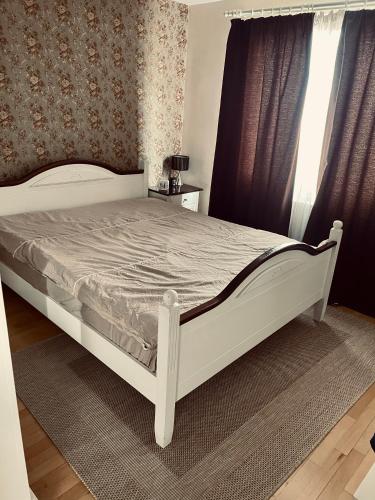 ein weißes Bett in einem Schlafzimmer mit einem Fenster in der Unterkunft Nomad Reghin in Reghin