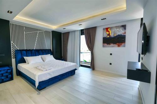 a bedroom with a bed and a flat screen tv at Yedisu Villaları Family Only in Kemer