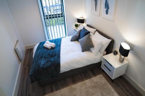 a bedroom with a bed with a blue blanket and a window at Modern 1-Bed Apartment - City Centre - FREE Wi-Fi - New - in Manchester