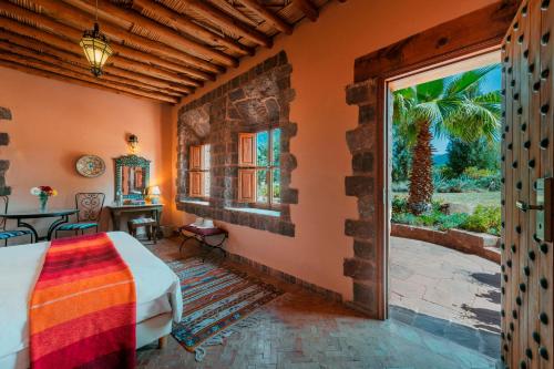 a bedroom with a bed and a large window at Kasbah Angour in Tahannout