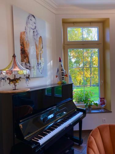 a piano in a living room with a window at Maison D'hôtes Sainte-Marie in Mirande