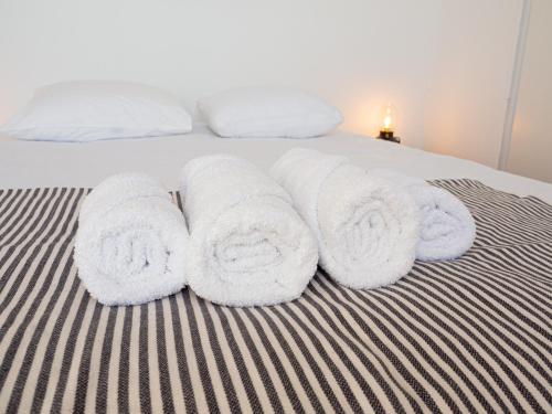 a group of towels sitting on top of a bed at Le Terracotta - Appartement centre ville avec balcon in Orange