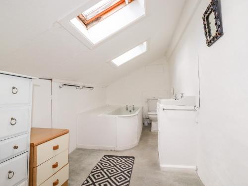a bathroom with a sink and a toilet and a skylight at Atlantic Farmhouse in Bude