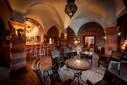 a restaurant with tables and chairs and a bar at Kasbah Angour in Tahannout
