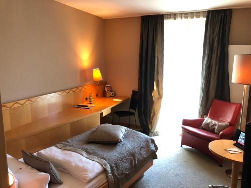 a hotel room with a bed and a desk and a chair at Hotel Gude in Kassel