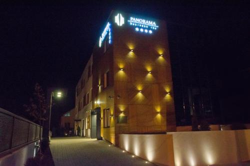 a building with a sign on the side of it at night at Panorama Business Inn in Cluj-Napoca