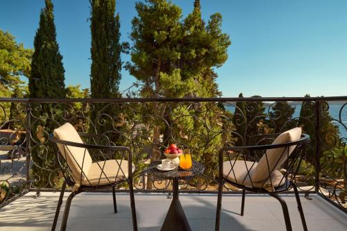 a patio with two chairs and a table on a balcony at Hotel Moeesy, Blue & Green Oasis in Hvar