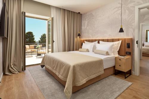 a bedroom with a large bed and a balcony at Hotel Moeesy, Blue & Green Oasis in Hvar