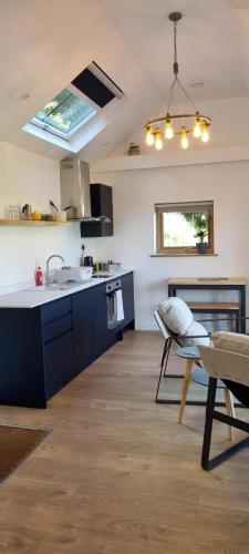 a kitchen with a sink and a stove top oven at The Brookhouse. Cheerful tiny house with Seaview. in Ilfracombe