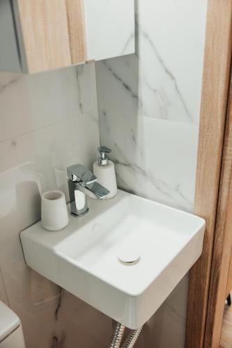 a white sink in a bathroom with a mirror at Little Villa in Makrirrákhi