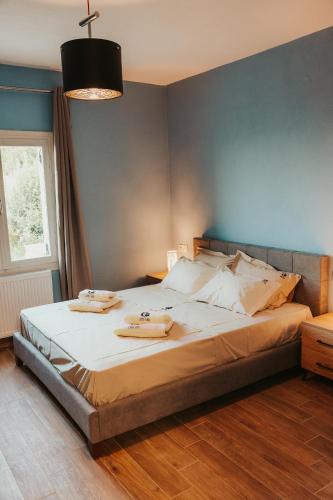 a bedroom with a large bed with a blue wall at Little Villa in Makrirrákhi
