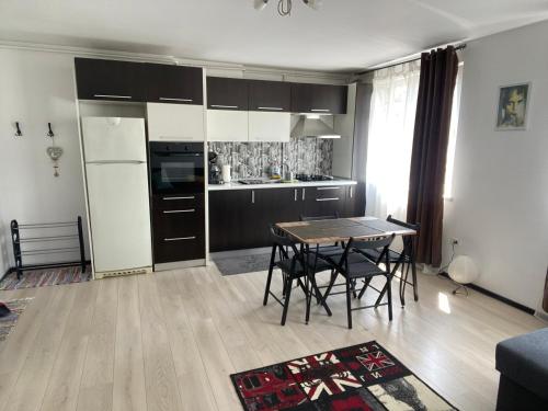 uma cozinha com mesa e cadeiras num quarto em Tourist Apartment 1 em Piatra Neamţ