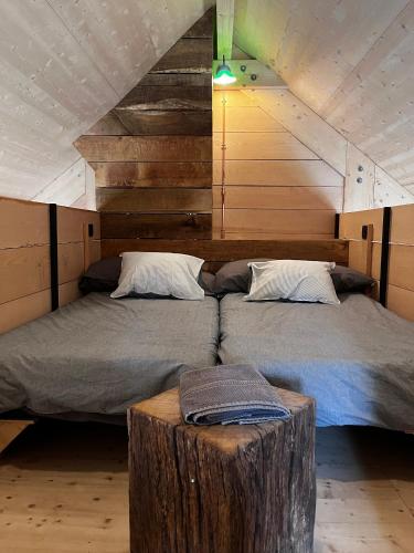 a bedroom with two beds and a tree stump in it at Enjoy Eco Lodge in Onhaye
