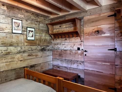 Enjoy Eco Lodge في Onhaye: غرفة نوم بسرير وجدار خشبي