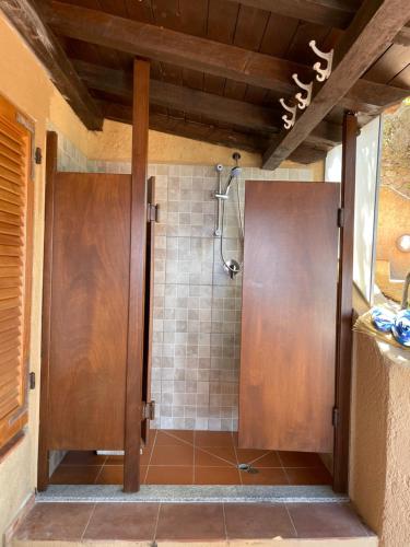y baño con ducha y puerta de madera. en Casa Faedda Costa Paradiso en Costa Paradiso