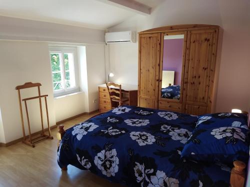 een slaapkamer met een bed met een blauw dekbed bij Gîte climatisé les hirondelles in Pons