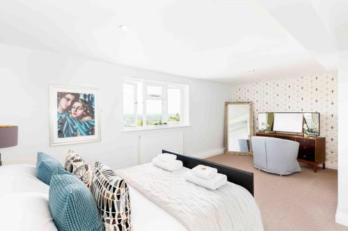 a white bedroom with two beds and a desk at The Old Morgan Period Apartments in Great Malvern