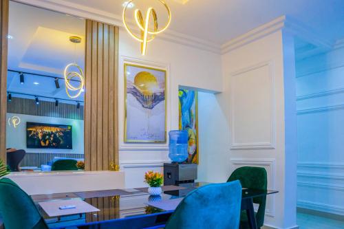 uma sala de jantar com uma mesa e cadeiras azuis em Plistbooking Xive 3 bedroom Luxury Abuja Apartment em Abuja